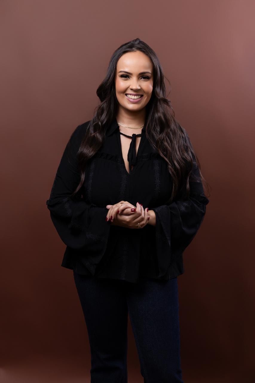 Vanessa Mello, psicóloga fundadora da Essenza, sorrindo com as mãos unidas